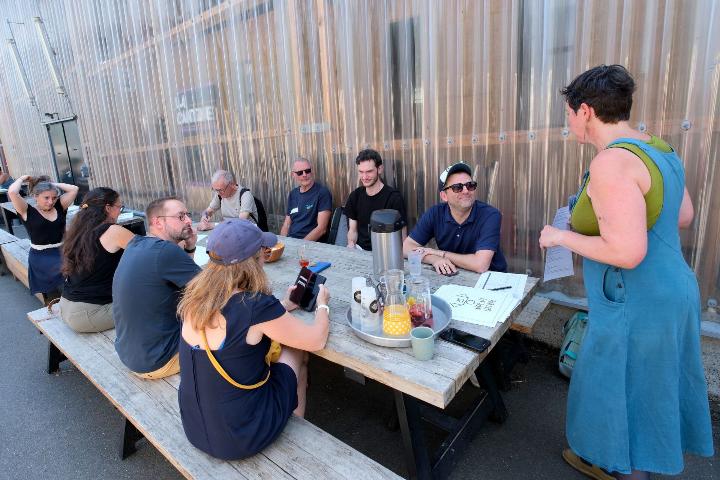 Les participant·es du local café commencent à s'intaller autour de la table. Photo par Marc Roger